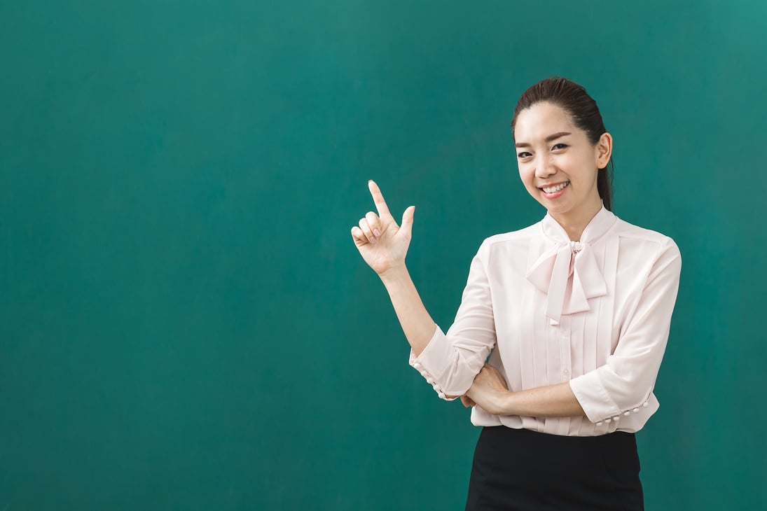 Asian teacher poses for photograph.